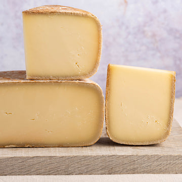 Cut pieces of ossau iraty cheese on a wooden board.