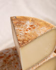 close up shot of a cut of ossai iraty sheep's milk cheese.