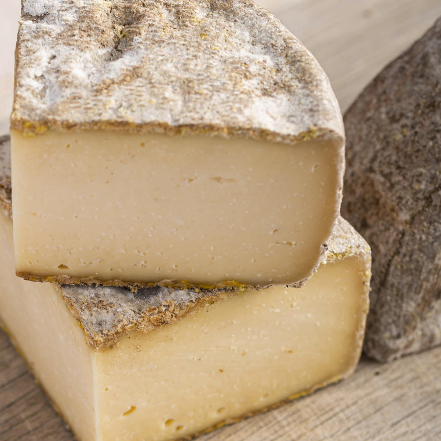 Cut pieces of French Tomme de Savoie hard cow's milk cheese.