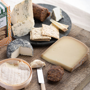 A selection of cuts of sheep and goat's cheese on a wooden board.