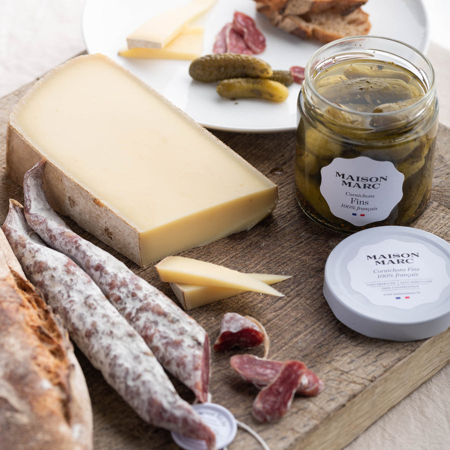 A selection board of cheese, charcuterie and pickles.