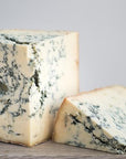 Cuts of Stilton blue cheese on a wooden board.