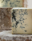A cut piece of Stilton blue cheese on a whole Stilton cheese.